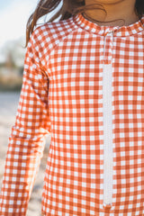 The long sleeve swimsuit for girls with rashguard and ruffle in Sienna Gingham by Grech and Co. Shop the best sustainable girl swimsuit online at MiliMilu.
