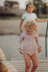 The long sleeve swimsuit in Sunset Meadow, made from recycled fabric and offering UPF 50+ protection, this sustainable girl swimsuit is trendy and practical.