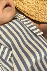 Extra light and breathable baby romper features blue and white stripes. Crafted from organic cotton, it has adjustable straps to ensure a longer fit.
