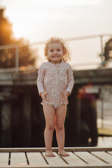 The long sleeve swimsuit in Sunset Meadow, made from recycled fabric and offering UPF 50+ protection, this sustainable girl swimsuit is trendy and practical.