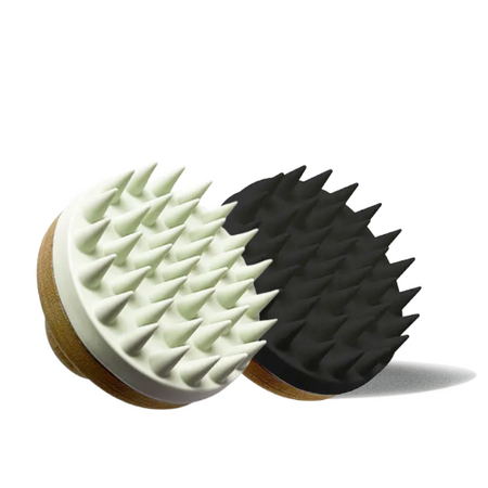 Two massage brushes, one white and one black, on a white background.