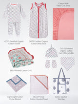 Collection of organic cotton baby products including pajamas, sleep sack, quilt, blanket, towel, and tote bag on a white background.