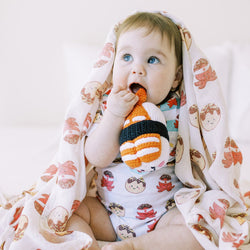 girl holding the wee bean sustainable and handmade fair trade rattle dolls by pebblechild in ebi shrimp sushi