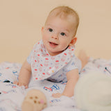 cute baby looking up in yogurt drink bib