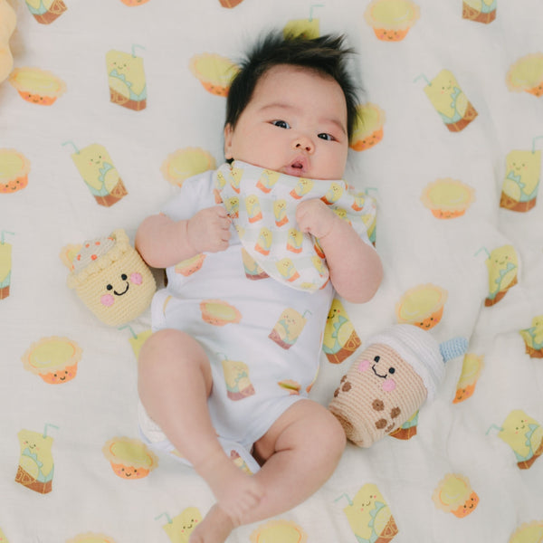 cute baby laying down in the wee bean lemon tea and egg tart onesie and swaddle