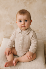 Baby boy wearing light gey muslin baby romper